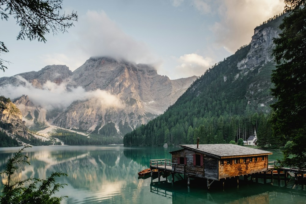 Alpine lake reflecting mountains and a lakeside cabin